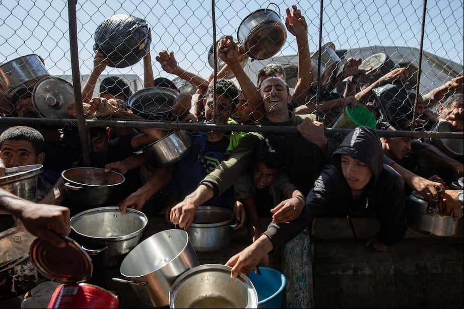 Palestinos desplazados internos se reúnen frente a un comedor social para recibir raciones limitadas ante la escasez de alimentos, en Khan Younis, al sur de la Franja de Gaza, el 30 de mayo de 2025. Naciones Unidas ha advertido que "toda la población de Gaza corre el riesgo de hambruna".