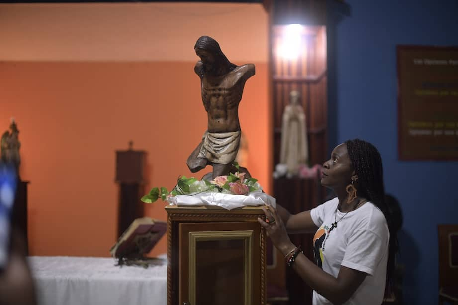 Una mujer junto al Cristo mutilado en el primer día de la conmemoración de los 20 años de la masacre.