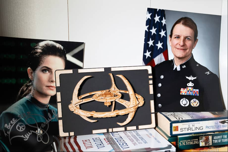 El retrato de la Coronel Bree Fram en la Fuerza Espacial se encuentra junto a una foto firmada por la estrella de Star Trek, Terry Farrell, en su domicilio el 9 de marzo de 2025 en Reston, Virginia. La Coronel Bree Fram ha servido en el ejército estadounidense durante 22 años, pero ahora se enfrenta a la destitución de la Fuerza Espacial debido a la prohibición impuesta por el presidente Donald Trump a las tropas transgénero.