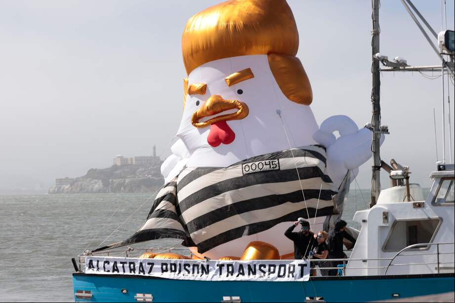 Un globo inflable con forma de Donald Trump, vestido con un traje de presidiario a rayas blancas y negras, navega en señal de protesta frente a la isla de Alcatraz.