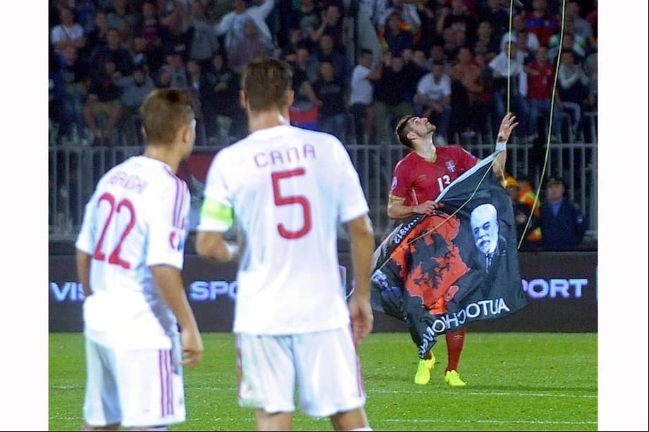 Foto de archivo. Los jugadores de Albania observan al defensa de Serbia Stefan Mitrovic mientras toma una bandera con símbolos nacionales albaneses desde un dron operado a distancia.